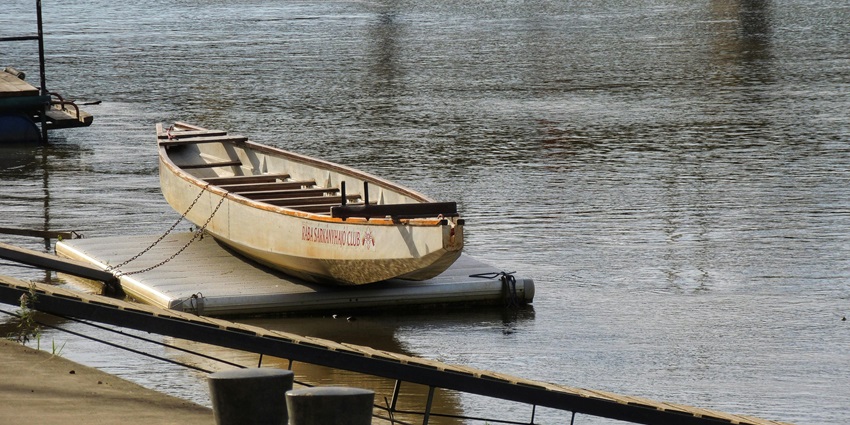 The natural beauty of the pristine lake includes greenery and wildflowers surrounding it.