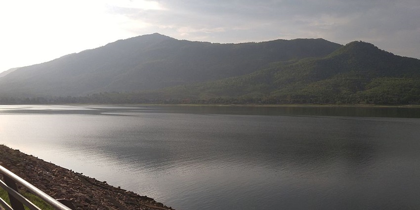 Dimna Lake with sandy shoreline, railings and a large water body with mountains