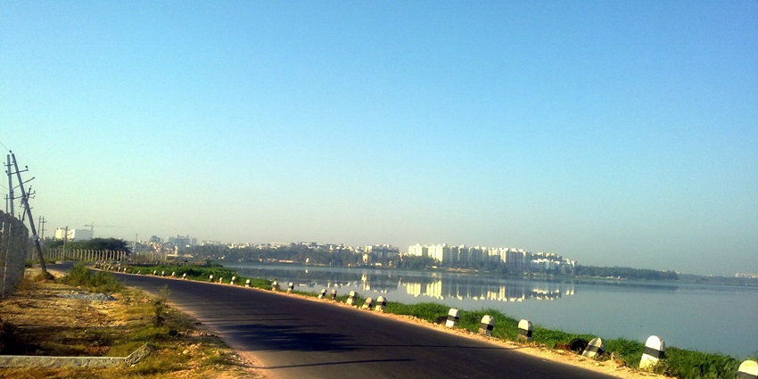 An image of Bellandur Lake in Bangalore, showing a vast waterbody with urban surroundings.
