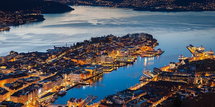 An image showing the illuminated Bergen night view from Fløyen, highlighting its charm