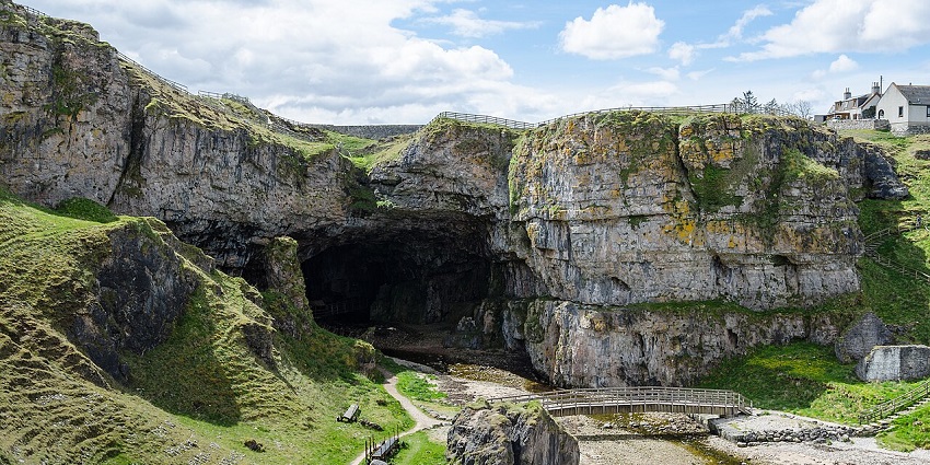 Entrance to a cave similar to Bone Caves, a site in Scotland, set in a rugged cliffside