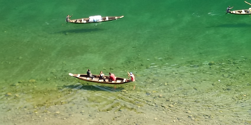 A picture of the cleanest lake in Meghalaya, reflecting the vibrant hues of the sky.