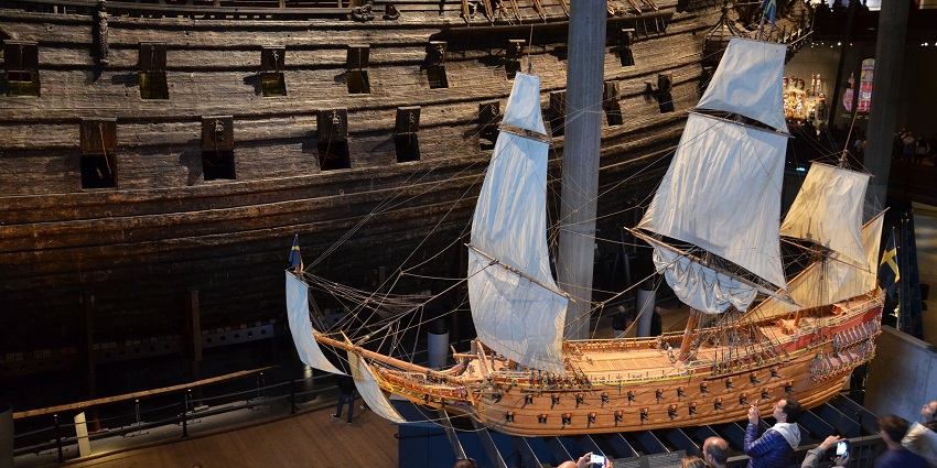 An image showing the interior of the Vasa Museum, with visitors viewing its attractions.