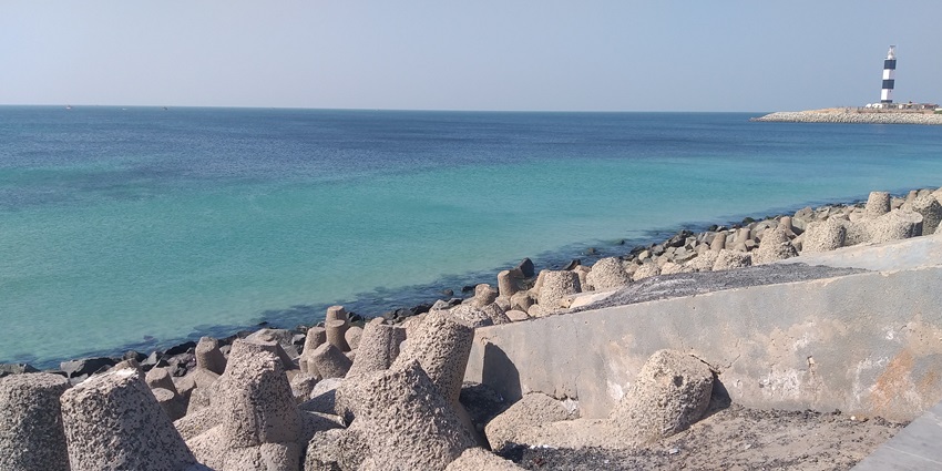 An image showing the sea at Bet Dwarka with gentle waves touching the sandy shoreline.
