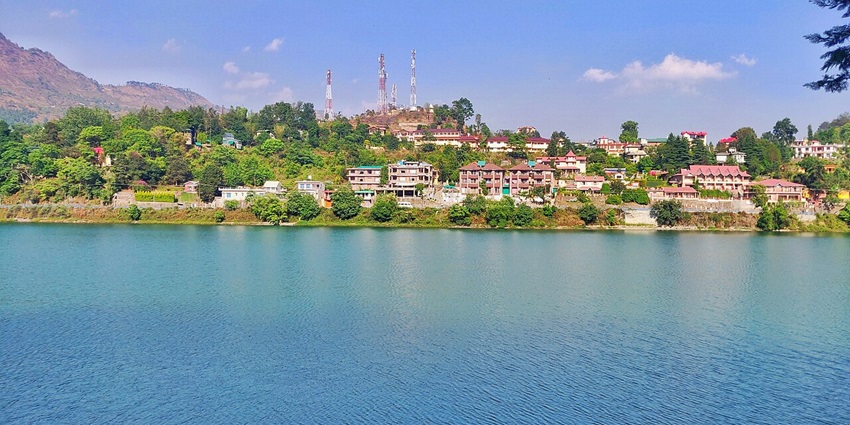 An image showing an amazing view of Bhimtal Lake, surrounded by greenery and calm waters