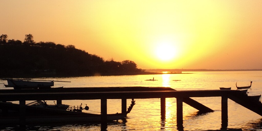 Image of Raja Bhoj wetlands in Madhya Pradesh, with wooden pier, and boats near the pier