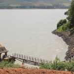 Shanthi Sagara Lake with a very large water body, people standing near the bridge.