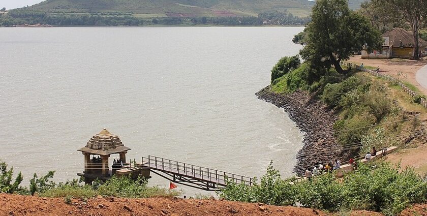 Shanthi Sagara Lake with a very large water body, people standing near the bridge.