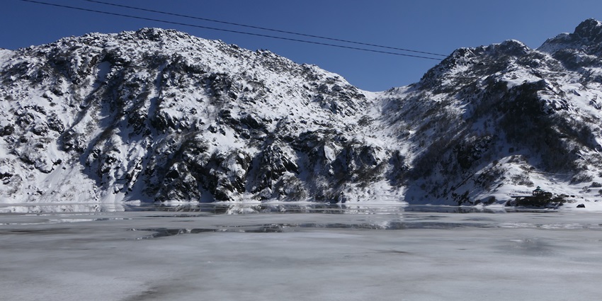 Landscape of Tsomgo Lake with mountains covered in white snow and frozen Tsomgo Lake