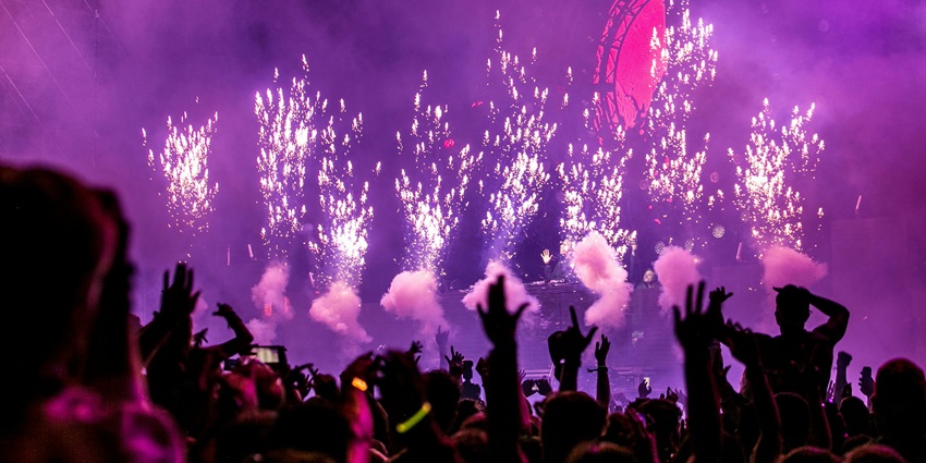 An image of a crowd enjoying and dancing to a DJ resembling Kyrgyzstan Nightlife.