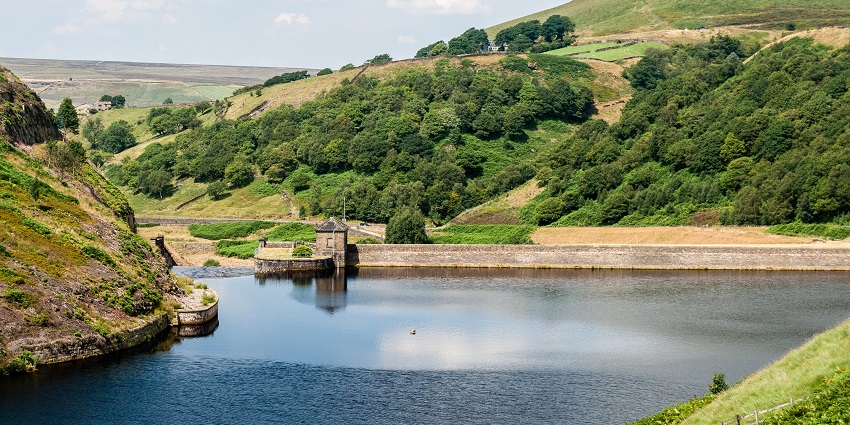 Blakeley Reservoir with trees showing autumn colours and hills around
