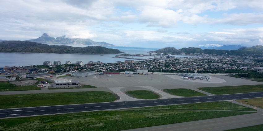 An image of the Bodø Airport with its terminal located near coastal areas.
