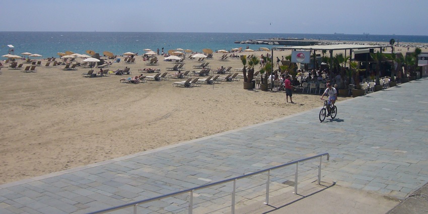 Image of a beach view with serene environment - Gentle waves touch the sand on the Bogatell Beach