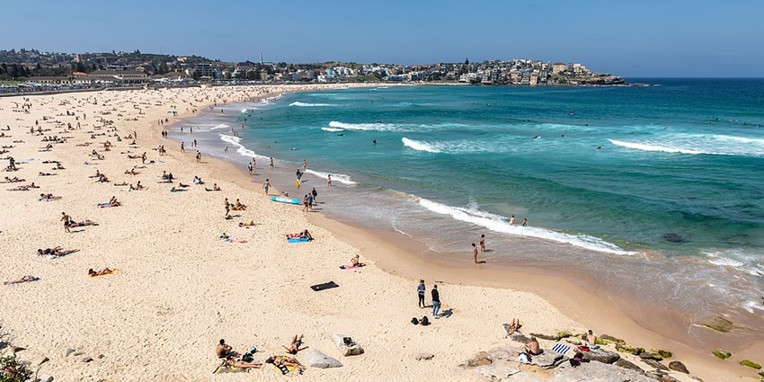 A sunny day at Bondi Beach with golden sands, clear waters, and a lively atmosphere.