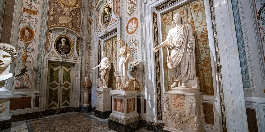 An ornate gallery in the Galleria Borghese in Italy, showcasing classical sculptures