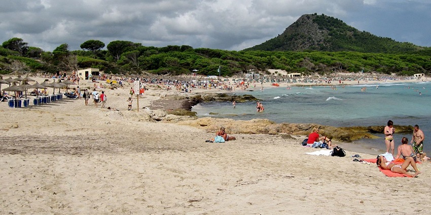 Image of people taking sunbath in Cala Agulla, among beaches in Majorca Spain