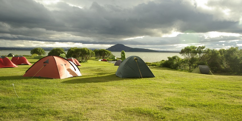 Experience tranquility camping amidst lush green meadows and mountains.