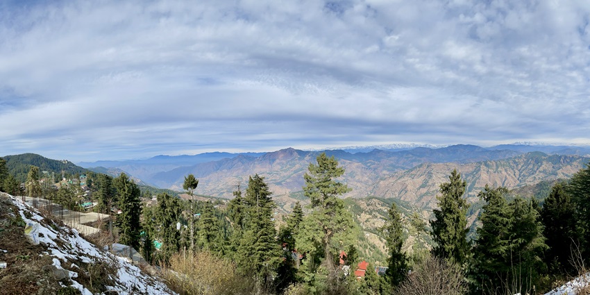 A panoramic view of the lush green mountains of Chail under a cover of a cloudy sky