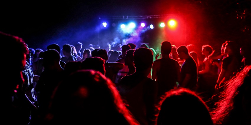 A crowd dancing at a nightclub in Chandigarh, with colourful stage lights in the background.