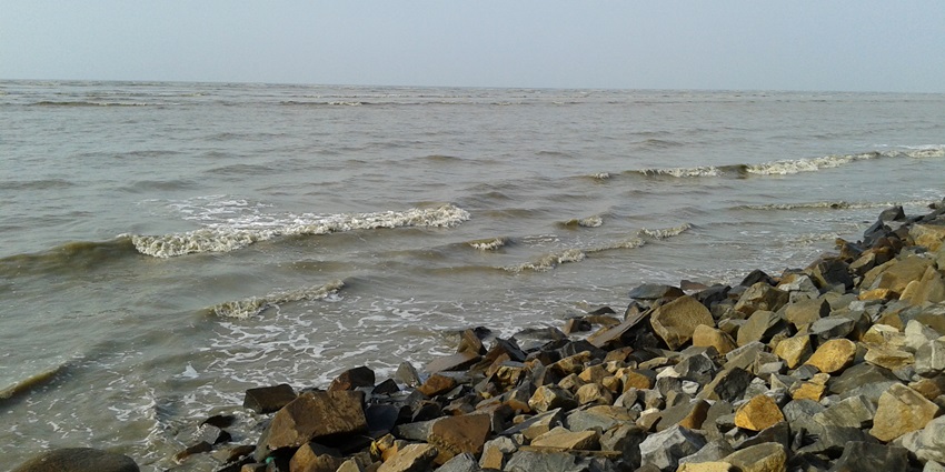 An image showing sunrise at Chandipur Sea Beach with the sun’s reflection on the wet sand.