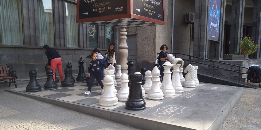 Children enjoying Yerevan’s nightlife and playing chess at Charles Aznavour Square.