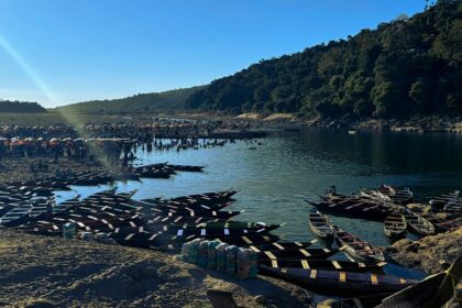 A picture of the cleanest lake in Meghalaya, with crystal-clear waters reflecting the lush greenery around it.