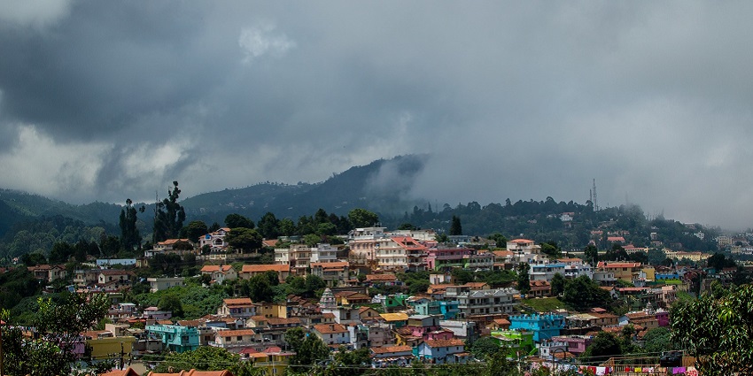 An image showing the houses and valleys on a foggy and cloudy day in Coonoor, Tamil Nadu.
