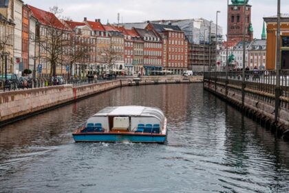 An image of Copenhagen's waterfront with boats and historical buildings in the background.