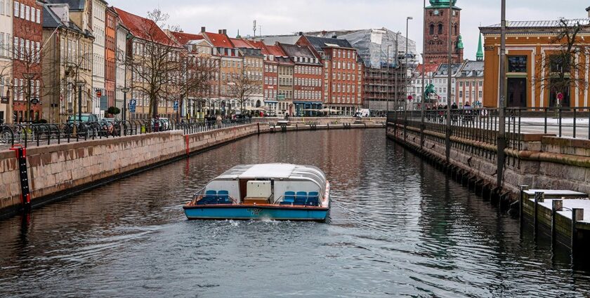 An image of Copenhagen's waterfront with boats and historical buildings in the background.