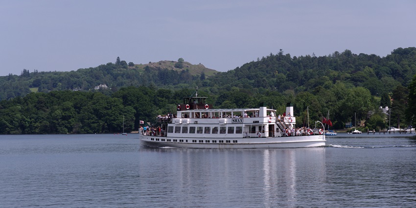 An image of a cruise ship sailing through Lake Windermere heading from Lakeside to Bowness