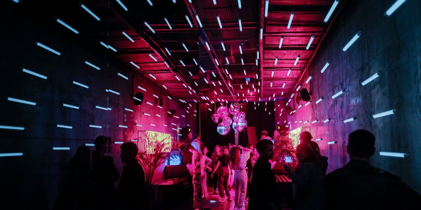 A neon-lit club with a vibrant crowd and futuristic lighting similar to Culture Box.