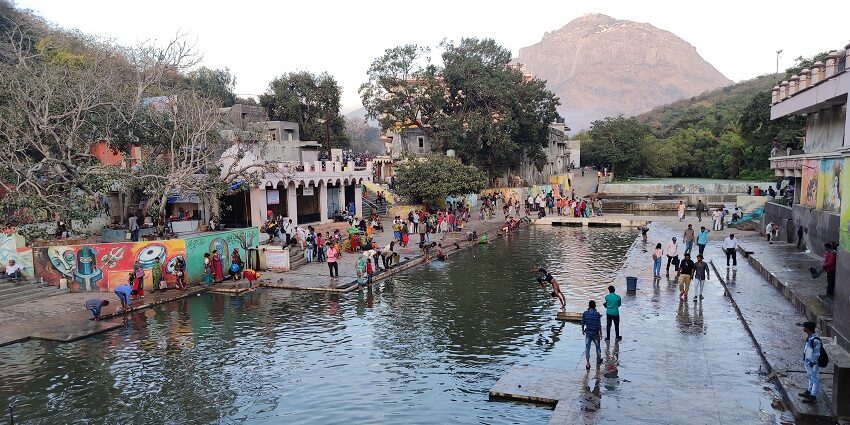 Damodar Kund in Junagadh, Gujarat, with sacred waters, temple structures, and greenery.
