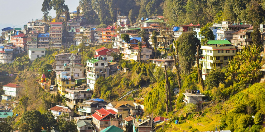 An image of the Darjeeling Himalayan Railway with a backdrop of snow-covered peaks.