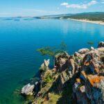 An image of a breathtaking view of one of the deepest lakes in the world, surrounded by stunning natural landscapes