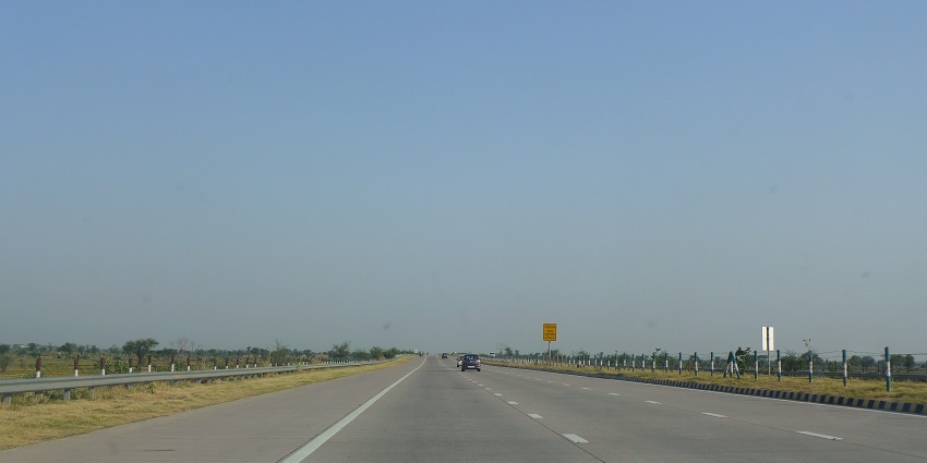Image of yamuna expressway highway stretching to the horizon under a clear blue sky