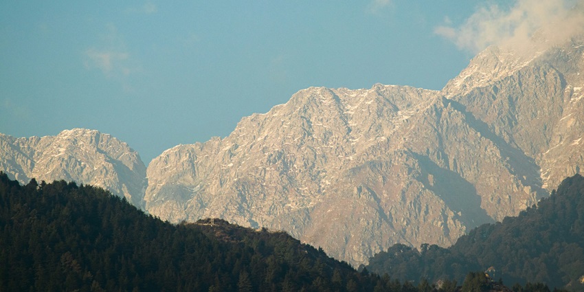 An image of the snow-clad Dhauladhar mountains seen from Dharamshala, with Tibetan monasteries in the foreground.