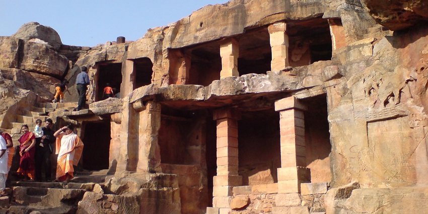 An image of the Dhaulagiri caves, amongst the most famous buddhist caves in India, with people exploring the site
