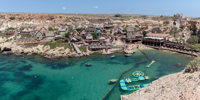 Explore Popeye’s Village, a colourful seaside film set - one of the things to do in Malta in October.