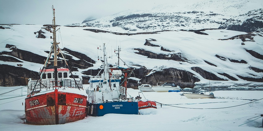 An Image of Disko Island, showcasing boats that are sitting on ice Greenland