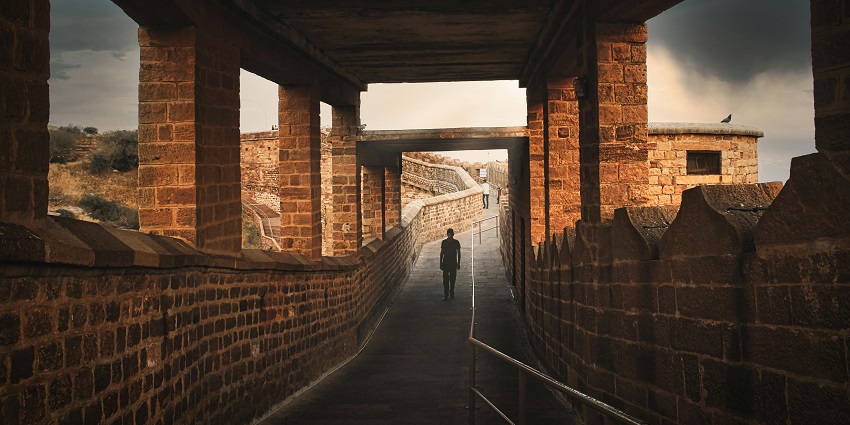 Image of a fort ruins, people strolling around the mesmerising greenery
