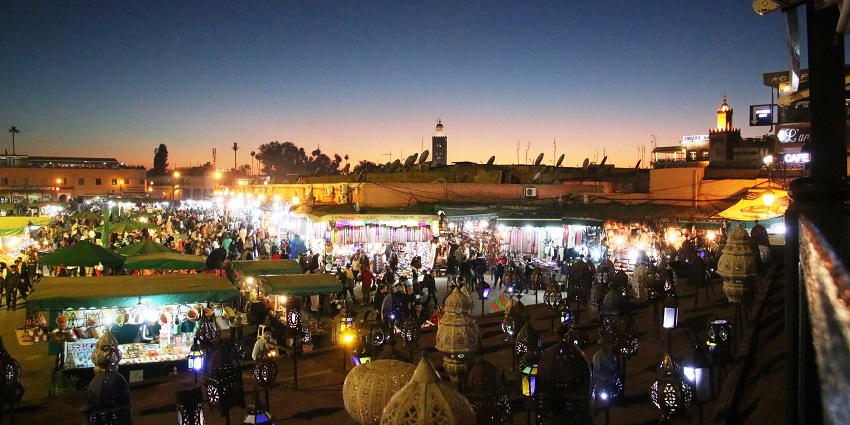 Djemaa el-Fna square at night with musicians, snake charmers, and acrobats, enhancing Marrakech nightlife.