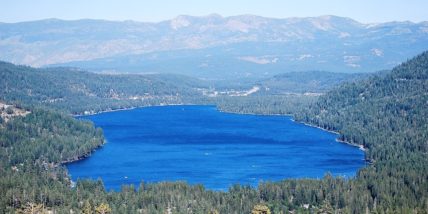 Donner Lake from McClashan Point surrounded by tall green trees and hills in the back