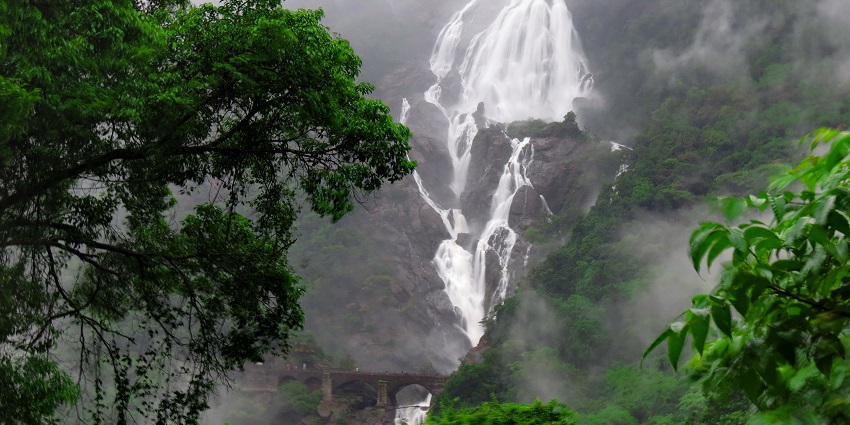 Majestic Dudhsagar Waterfalls with a railway bridge in the foothills in South Goa.