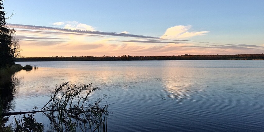 Eagle Lake in the evening with a reflection of the sky on the lake and trees on the side