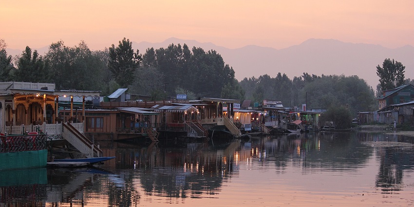 An eco-friendly type of houseboat in Srinagar Dal Lake with solar panels and sustainable materials.