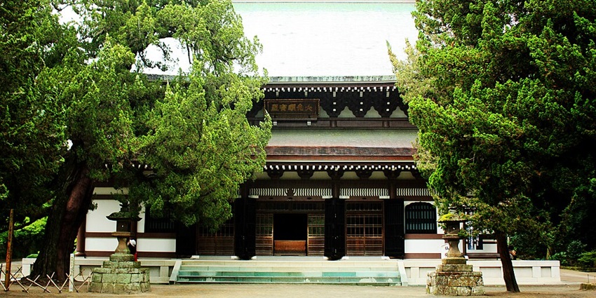 Engaku-ji Temple’s ancient wooden gate amid lush trees, a Zen retreat in Kamakura.