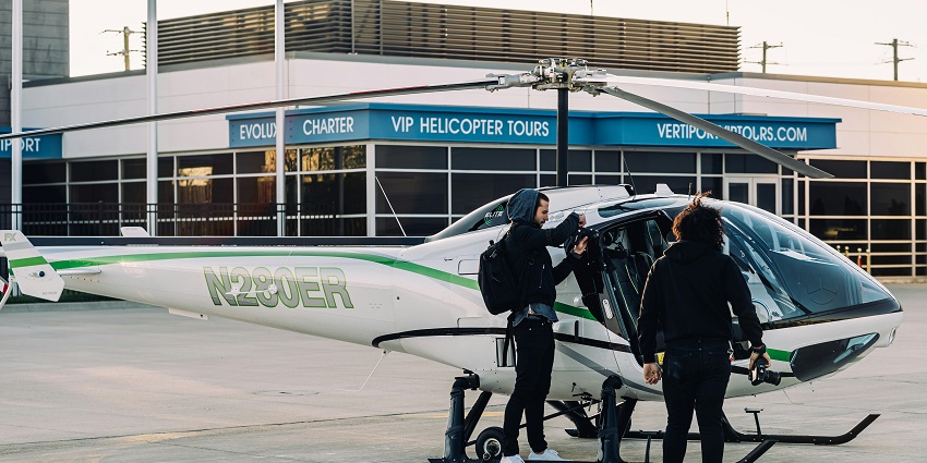 an image showing people standing near a helicopter, preparing for an exciting tour.
