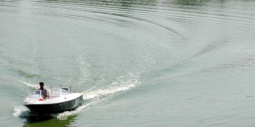 A visitor is riding a motorboat at Kankaria Lake and enjoying the serenity of the lake