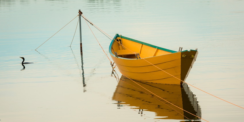 Scenic view of the boating at Wular Lake with clear water and reflection of the clear sky.