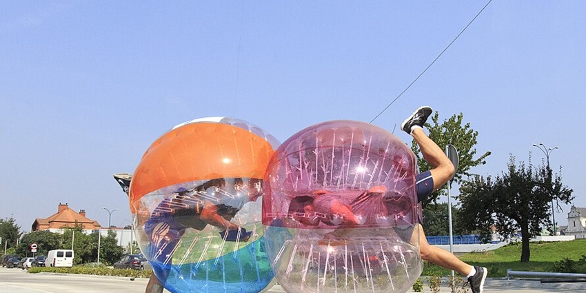 Friends having a blast in Bubble Mayhem, colliding and tumbling in giant bubble suits